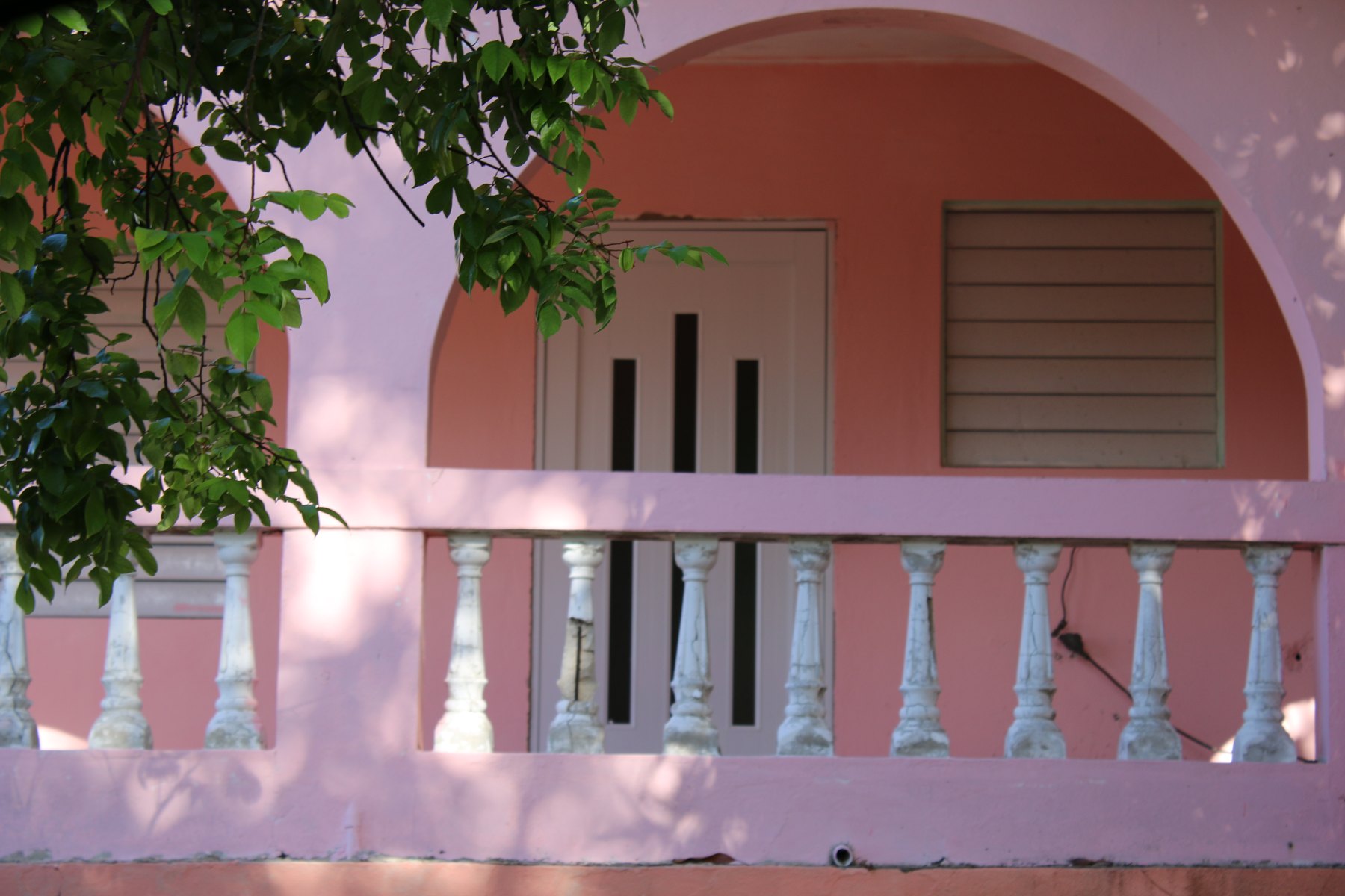 Balcón rosado y vegetación en Vieques.